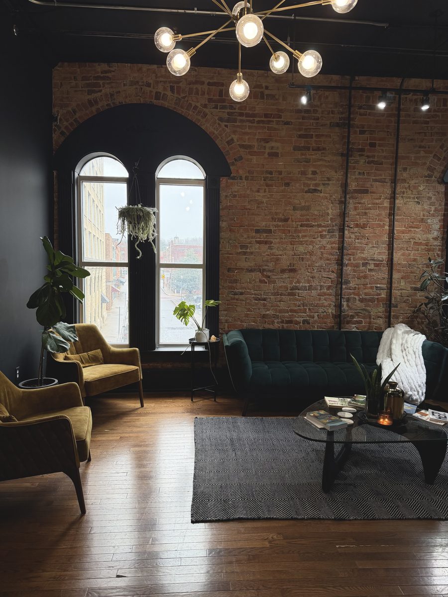 NUYU Hair Lounge interior with exposed brick and velvet seating